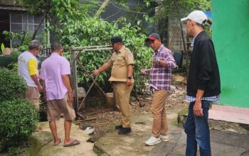 Sukron Ma'mun Lurah Bedahan (baju dinas) dan LPM Rizal Antoni (topi putih) sedang tinjau saluran air (Foto: Yudi Bahtiar/Starindonews.com)
