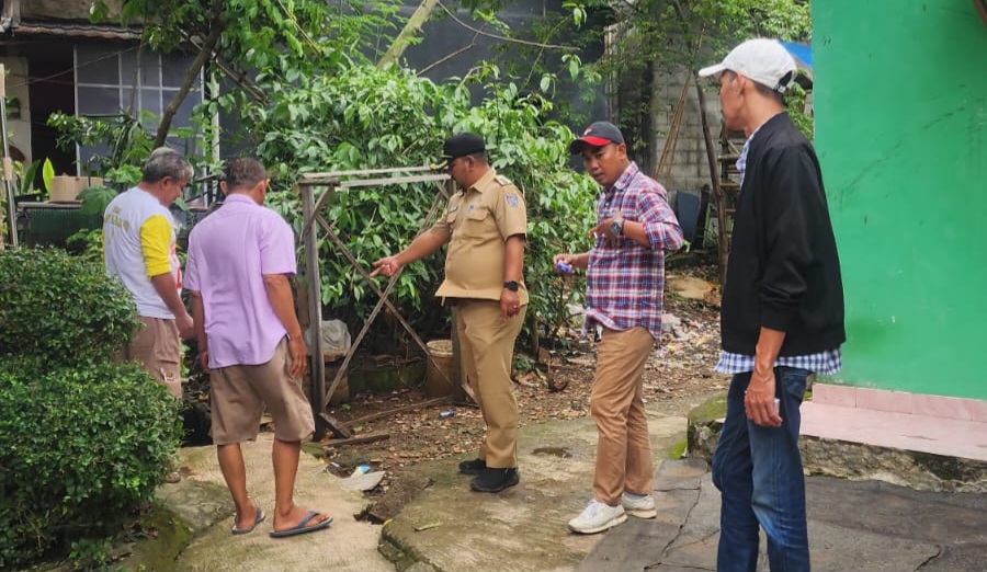 Sukron Ma'mun Lurah Bedahan (baju dinas) dan LPM Rizal Antoni (topi putih) sedang tinjau saluran air (Foto: Yudi Bahtiar/Starindonews.com)