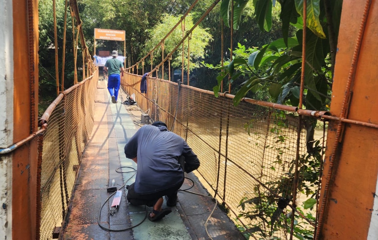 Perkerjaan perbaikan Jembatan Orange yang menghubungkan dua Kecamatan (Foto: Starindonews/Yudi Bahtiar)
